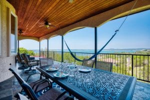 rental house covered balcony with eating area, seating area, and a beautiful view of the lake