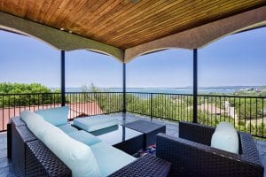 Rental house covered balcony with sectional seating area looking out to the lake