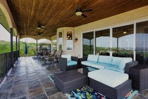 rental house covered balcony with sectional seating area, dining area, and easy chairs all with a beautiful view of Canyon Lake